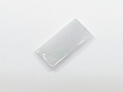 rectangular white jade stone on a white surface with a small hole in the middle