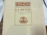 un livre posé sur une table, avec un stylo et du papier dessus