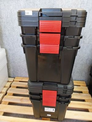 deux caisses noires et rouges empilées l'une sur l'autre sur une palette