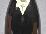 bottle of red wine sitting on a gray surface with a red cap