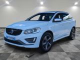 un SUV Volvo blanc garé dans un garage au sol carrelé