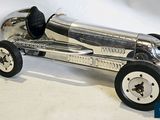 a metal model of a race car on a white surface