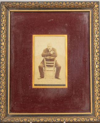 Photo encadrée d'un homme à la pipe assis à califourchon sur…