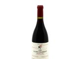 the bottle of red wine is sitting on a white surface