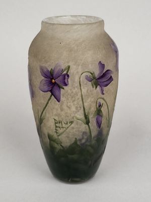 un vase sur lequel sont peintes des fleurs violettes sur un fond blanc