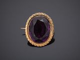 a close up of a purple stone in a gold ring