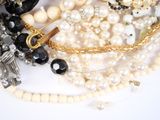 a pile of pearls and other jewelry on a white surface