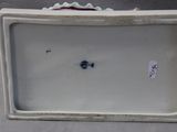 a white porcelain box with a flower decoration on it