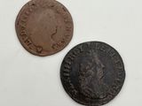 an old coin and a bronze coin on a white surface