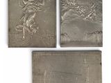 a set of four silver plaques depicting a statue of an angel and a building