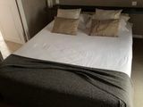 un lit recouvert d'une couverture dans une chambre
