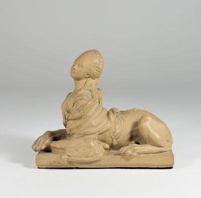statue of a woman laying on a pillow on a white surface