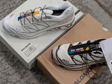 a shoe that is on the ground next to a box