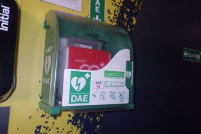 une armoire de secours verte et rouge sur un mur jaune
