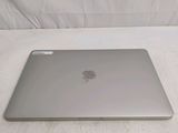 a silver apple laptop sitting on a white surface