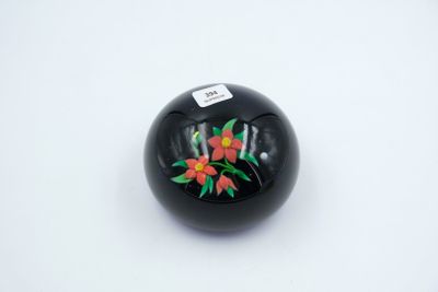 a black ball with flowers on it on a white surface