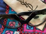 a pair of sunglasses and a pouch on a bed