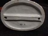 a white porcelain plate with a handle on it