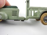 a hand holding a toy truck that is on a white surface