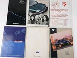 several books are sitting on top of a white table next to a blue car