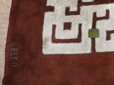 a brown and white rug with a green design on it