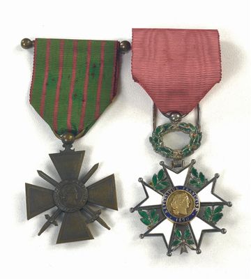 deux médailles et une croix sont disposées sur un fond blanc
