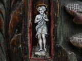 a statue of a boy holding a staff in a wooden frame