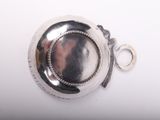 a silver plate with a ring on it on a white surface