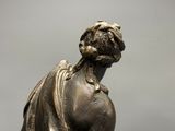 bronze statue of a woman holding a bird on her shoulder