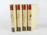 three books are lined up in a row on a white surface