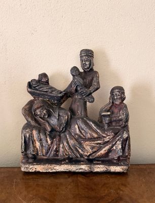 une figurine représentant trois personnes assises sur un lit