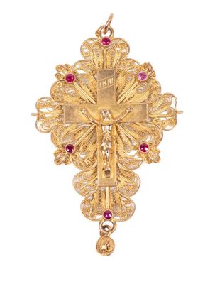 un gros plan d'une croix en or ornée de pierres rouges