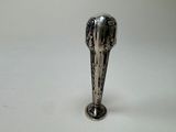a silver spoon with a bird on it sitting on a table