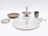 un plateau en argent et des couverts en argent posés sur une table blanche