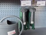un arrosoir posé sur une étagère dans un magasin