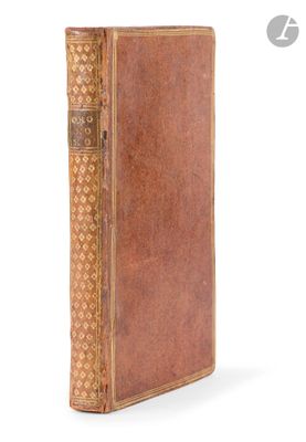 an old book with a brown cover sitting on top of a white surface