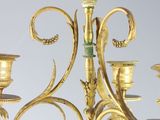 a gold colored chandelier with five candles on it