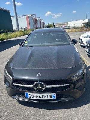 a black car parked in a parking lot next to other cars