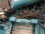 a corded drill and a tool in a box