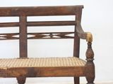 a wooden bench with a rattan seat on it