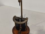 a small clock that is on a stand on a table