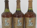 three bottles of wine sitting next to each other on a white surface