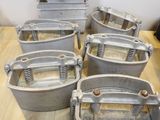 six large metal buckets sitting on top of a wooden table