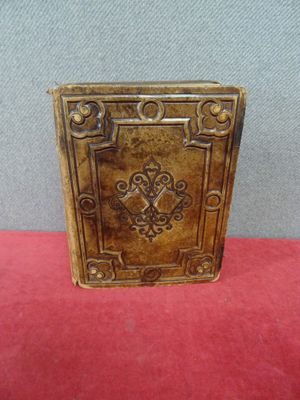 un vieux livre posé sur une table recouverte d'un tissu rouge