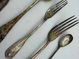 several spoons, forks, and spoon rest on a white surface