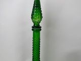a close up of a green glass bottle on a white surface