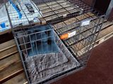 une cage contenant un chat, posée sur une palette