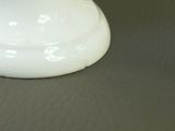 a white vase sitting on a table with a black background