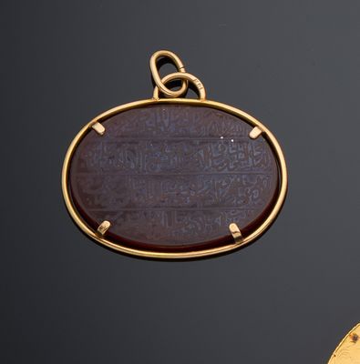 une image représentant un pendentif en or orné d'une pierre brune au centre