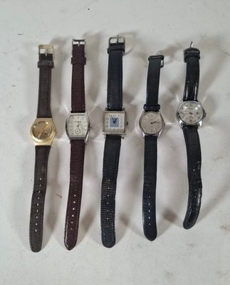 cinq montres différentes sont alignées sur une surface blanche